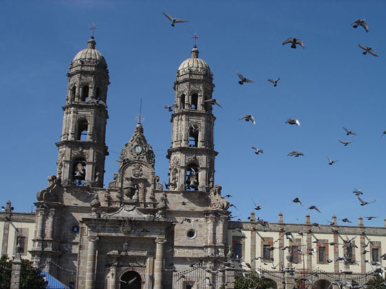 view on Zapopan Cathedral with flying pigeons